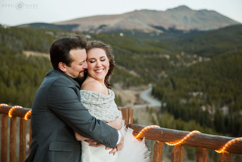 Snuggly wedding photo of a couple enjoying the mountain views at The Lodge at Breckenridge on their wedding day