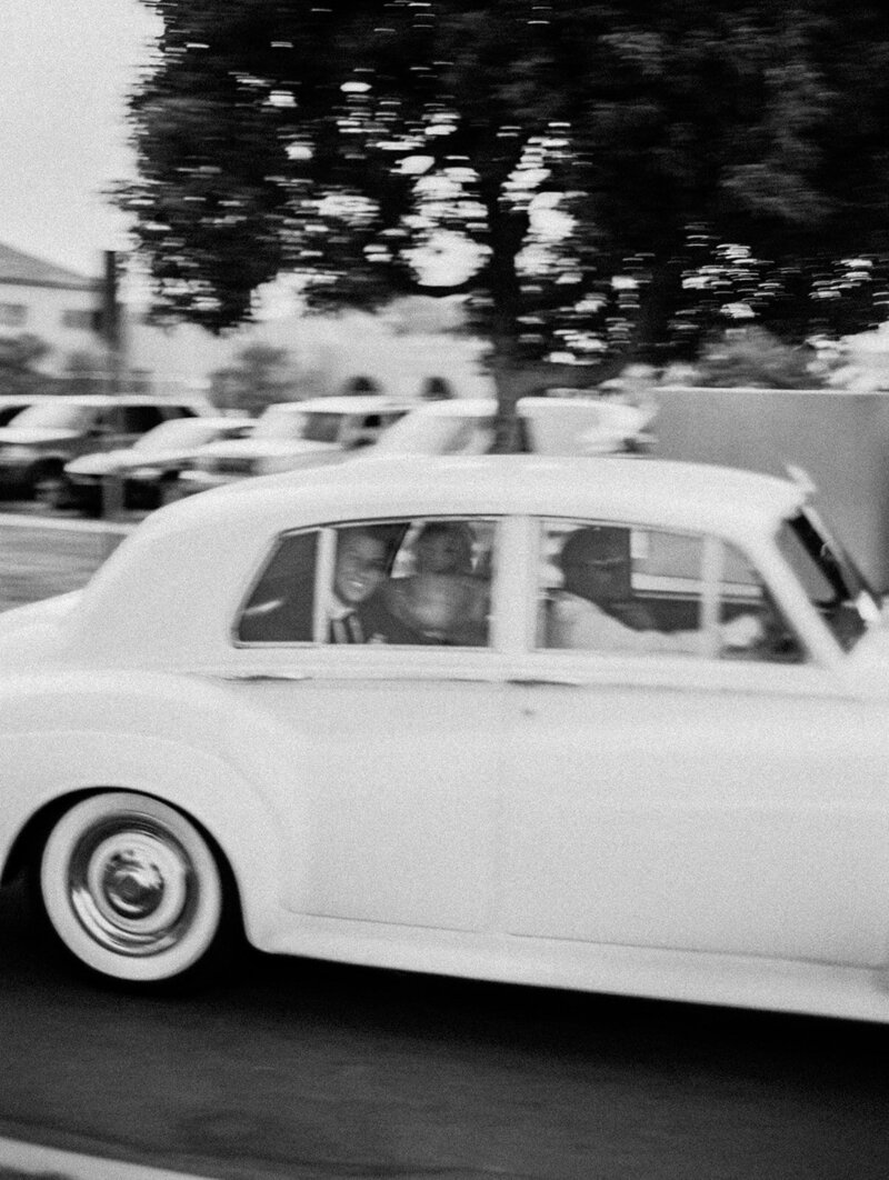 getaway car blurry image of newly wedded couple speeding by in classic roles royce