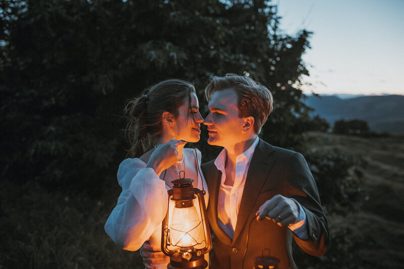 Bride and groom holding lanterns in the dark