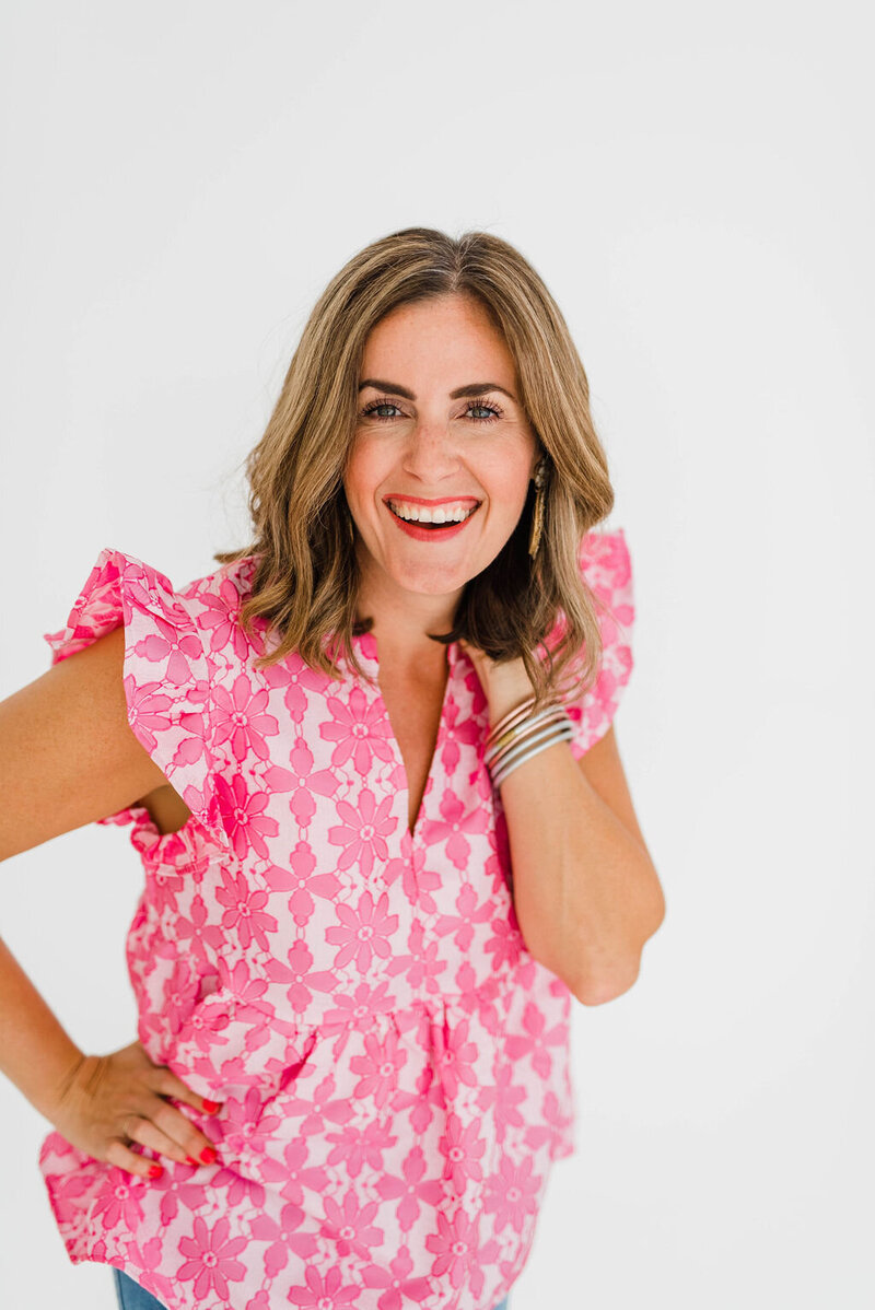 female business coach smiling at camera with pink floral top