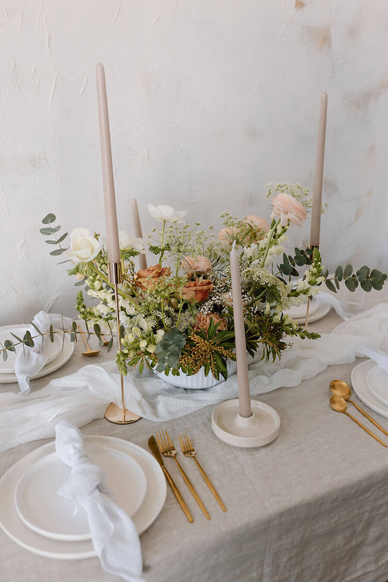 floral wedding tablescape with gold silverware and tall candles