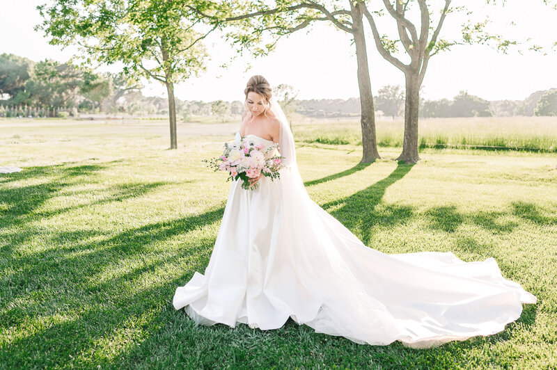 A brunette bride holding her wedding bouquet during her bridal portraits at Highrock Farms by Raleigh wedding photographer, JoLynn Photography