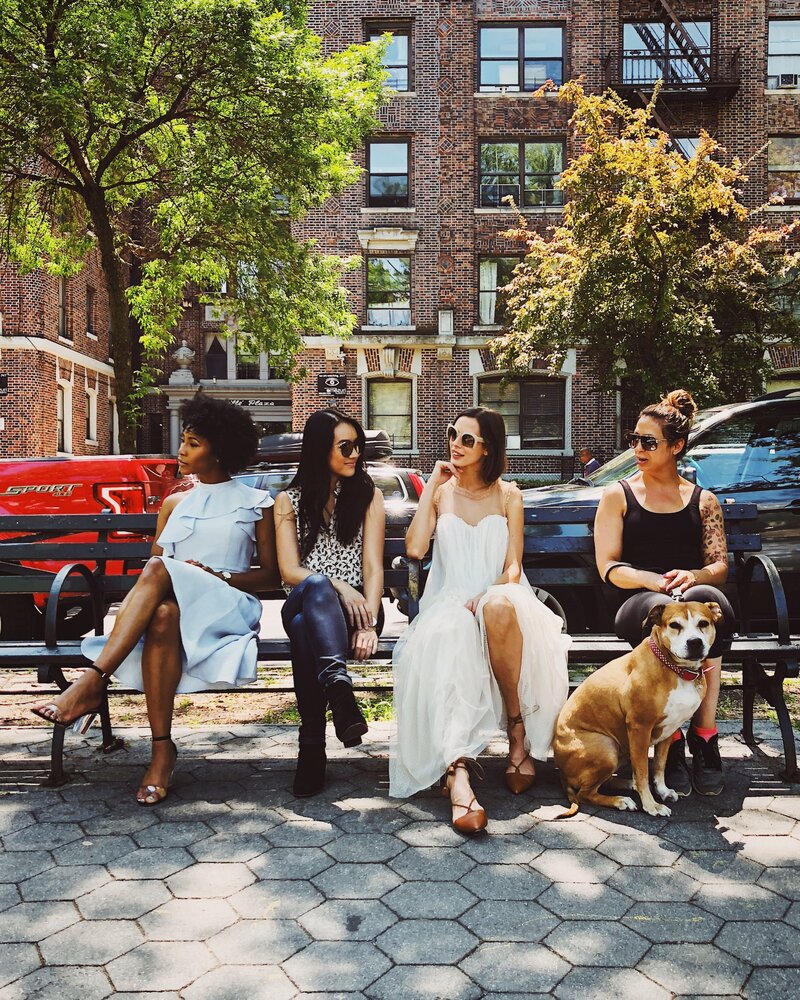 4 multiracial women sitting on bench next to dog in Charleston South Carolina