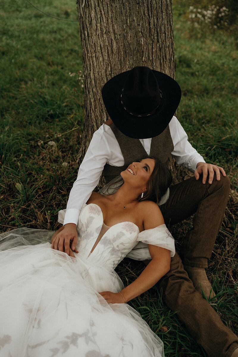 Rhode Island and Destination Wedding Photographer | Cinematic, Moody, Storytelling | Aisha Lee Photography | Bride and groom sitting by a tree