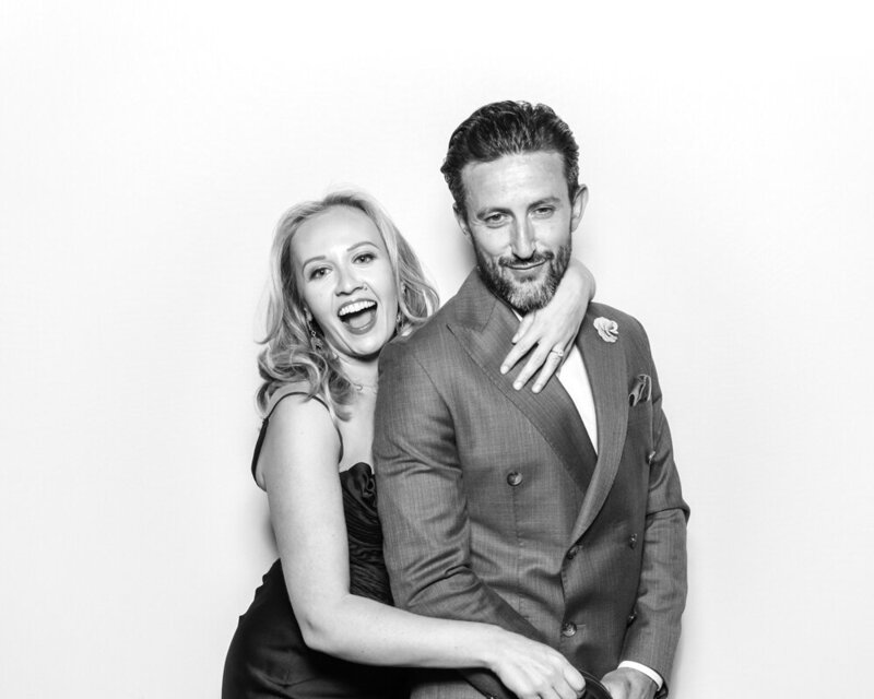 couple posing against a white backdrop for a b&w filter during a kardashian glam photo booth hire in cotswolds, oxfordshire