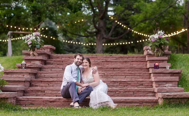 Casual photo of bride and groom sitting on red sandstone stairs at Riverbend at their June wedding in Lyons Colorado