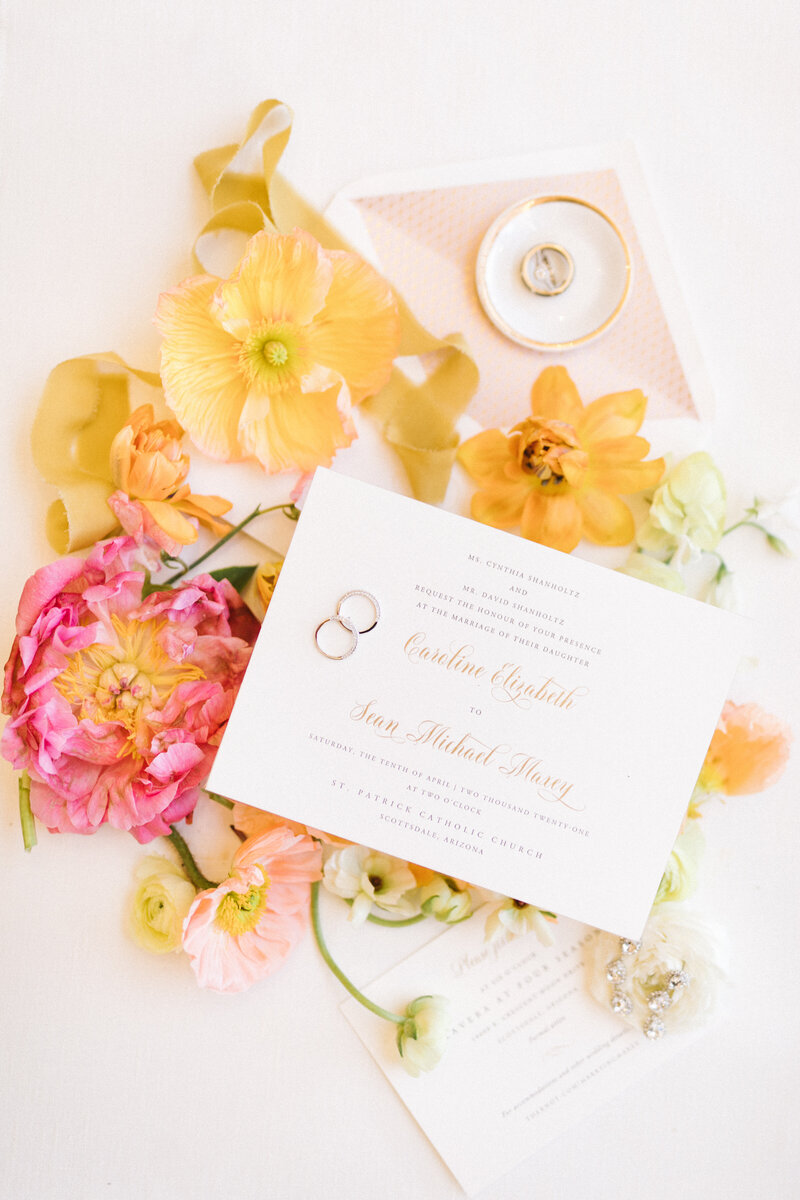 Wedding invitation and rings on flowers