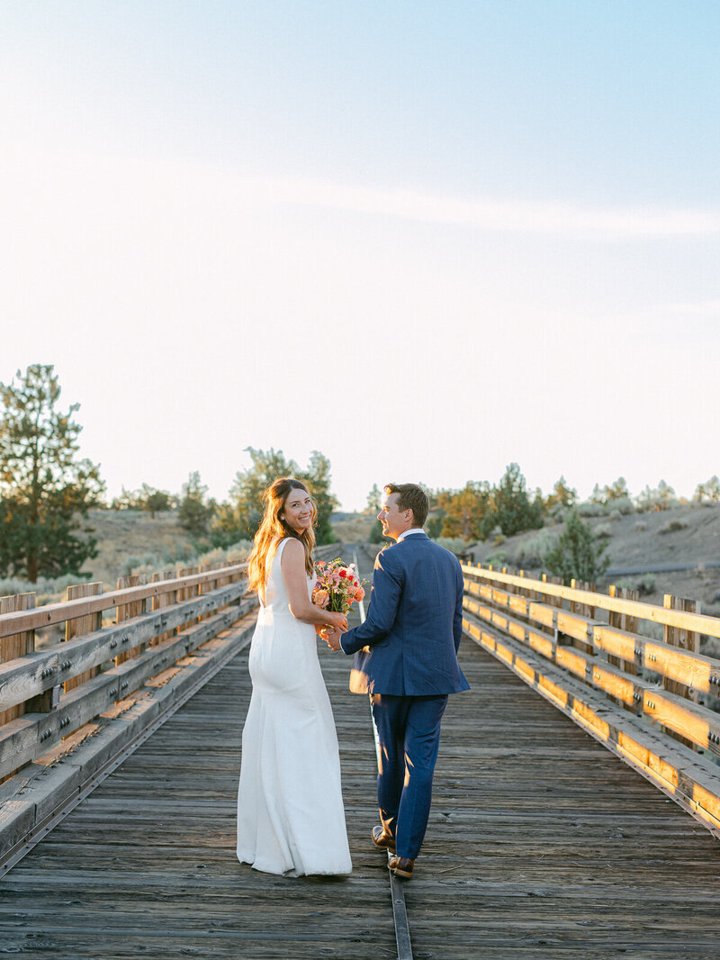 a bride and groom on the trestle bridge at brasada ranch