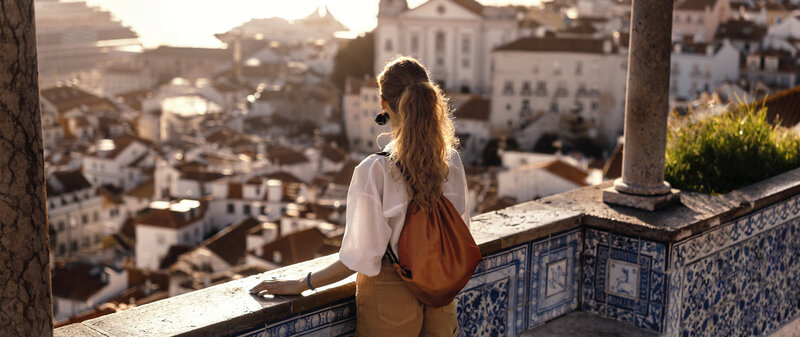 Woman overlooking town in Spain wearing backpack