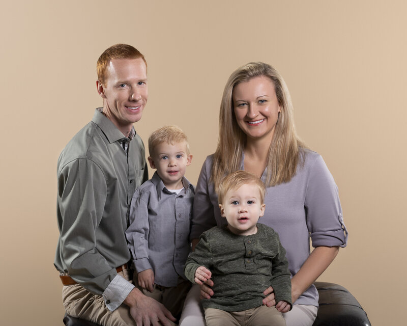 charlotte young family mom, dad and 2 boys smiling at the camera created in fort mill sc portrait studio