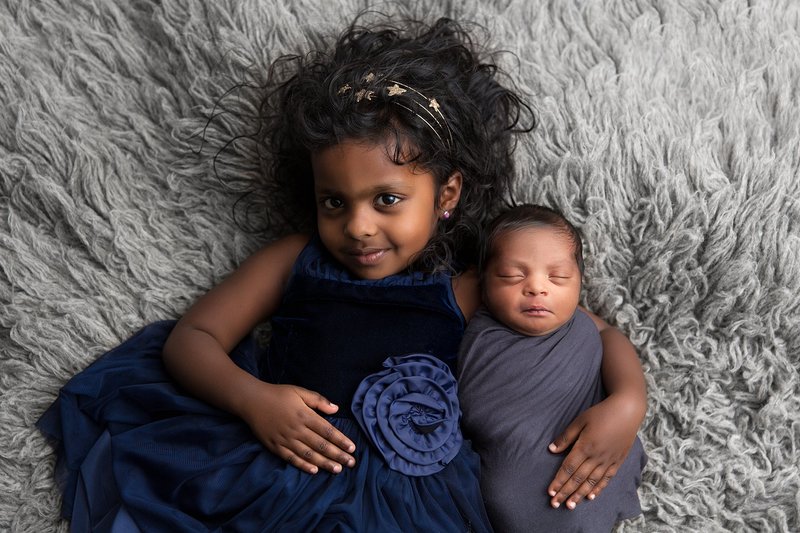 sister with newborn brother dark grey