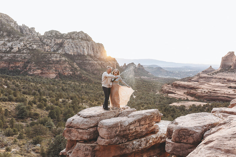 Married couple celebrating with champagne on top of a mountain in northern Arizona