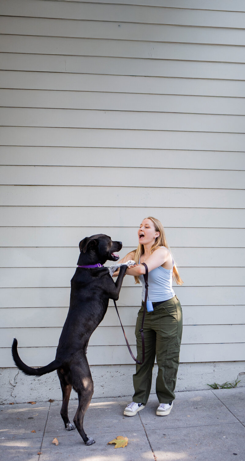 Krista Walsh (website copywriter) with her dog jumping up on her