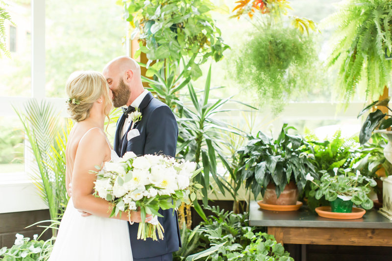 Bride and groom kissing at the Conservatory at Gervasi Vineyard photographed by akron ohio wedding photographer