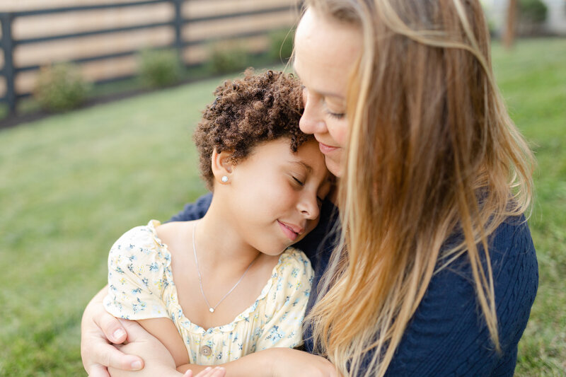 A mom hugs her daughter during an family photo session by Lexington KY photographer, Priscilla Baierlein.