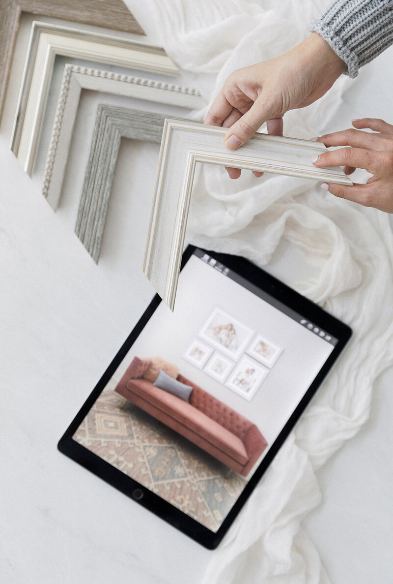 frame corner samples being held by hands above an iPad with a family portrait wall display by Tiffany Hix Photography