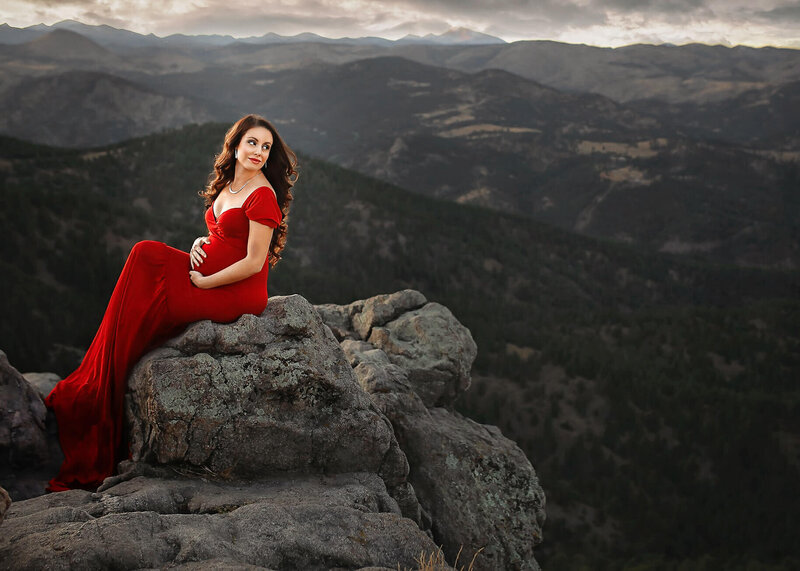 Beautiful regnant woman osing in front of rocky mountains
