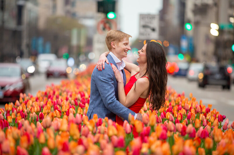 A creative magnificent mile engagement photo with tulips on Michigan ave in Chicago.
