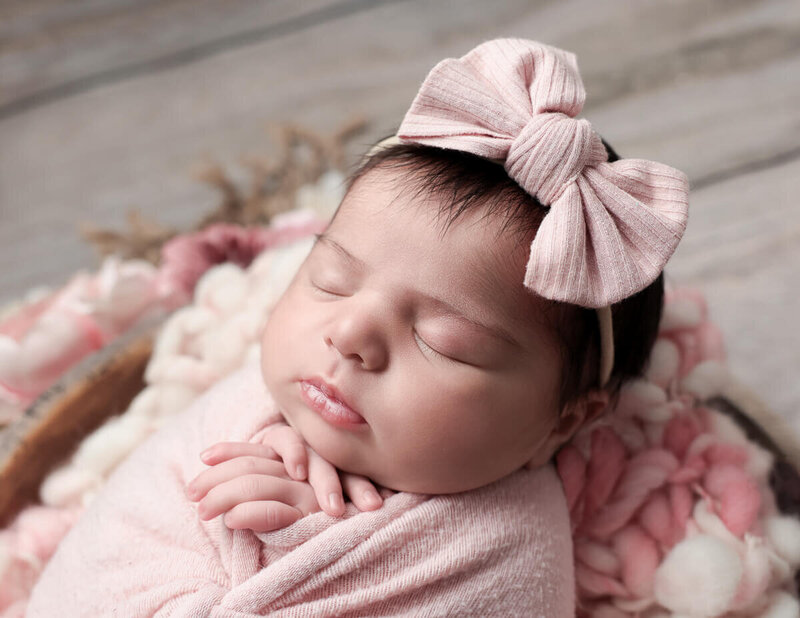 Side profile of a newborn girl captured during a studio photography session in Rochester, NY, showcasing her delicate features and peaceful expressions."