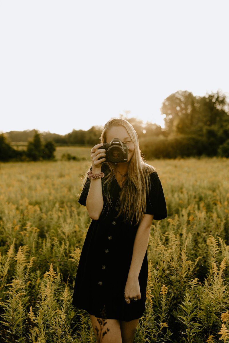 Photographer taking a picture in a yellow field at sunset