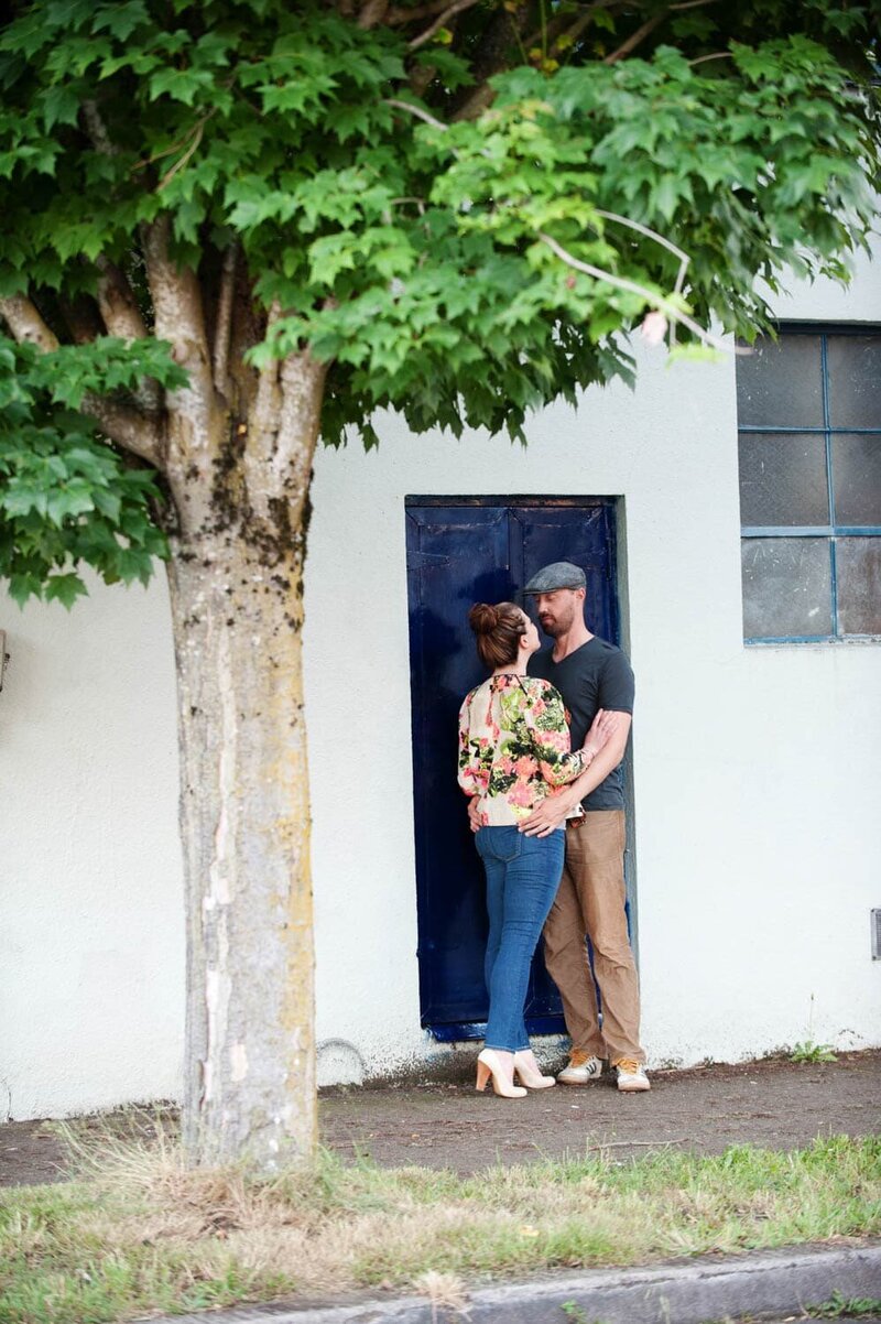 a man and woman stand in a bright blue doorway