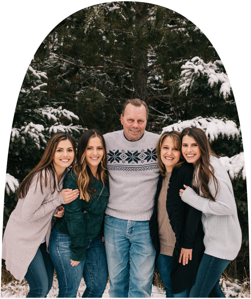 Jenna with her mom, dad, and sisters embracing and smiling at the camera