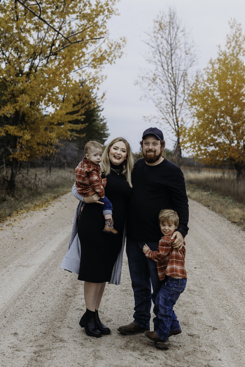 young family standing on gravel road