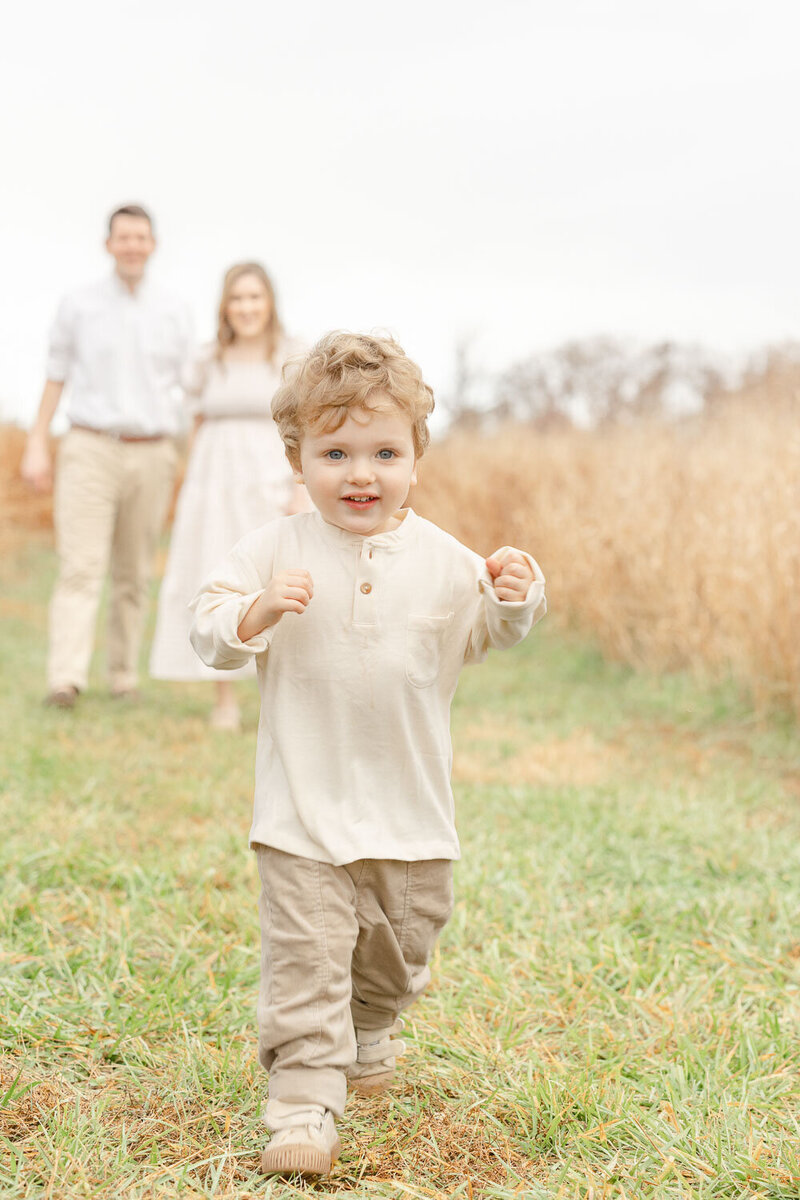 Toddler boy running away from parents taken by a photographer in Manassas, Virginia