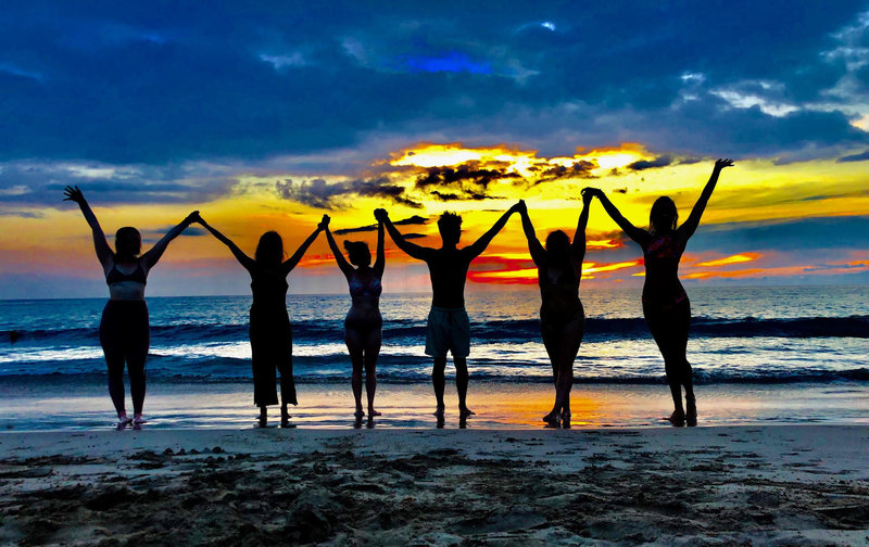 Joyful YTT Graduates on the beach in Hawaii at Sunset