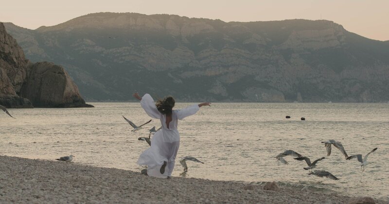 Frau in Kleid befreit und spielend die Möwen am Strand aufjagend: Jetzt bin ich dran – Selbstentfaltung und Lebensfreude