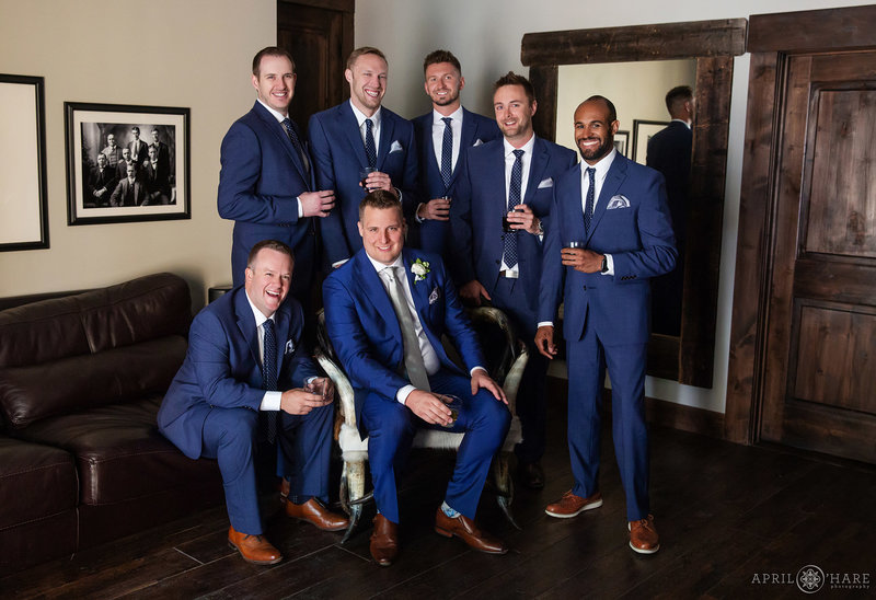 Groom with groomsmen group portrait inside the Groom's Room at Blackstone Rivers Ranch