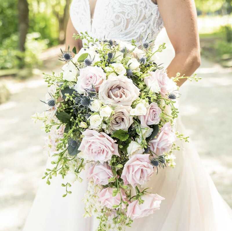 Gorgeous bride in a cream color dress holding flowers