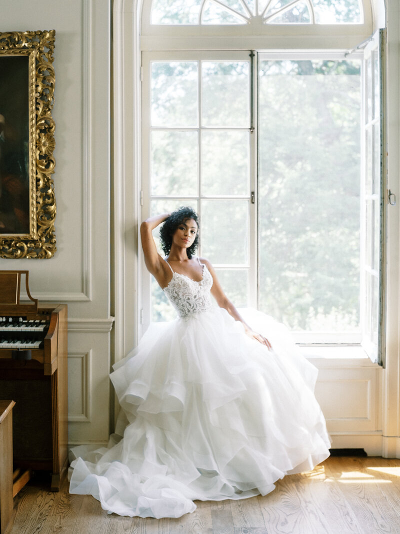 Bride sitting in mansion window for editorial photography