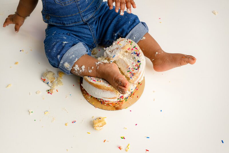 feet and legs of one year old girl in cake during  her smash session