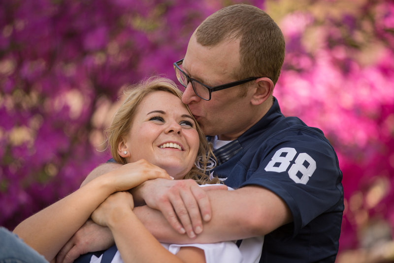 Man kisses the top of fiancee's head during Penn State Erie engagement session