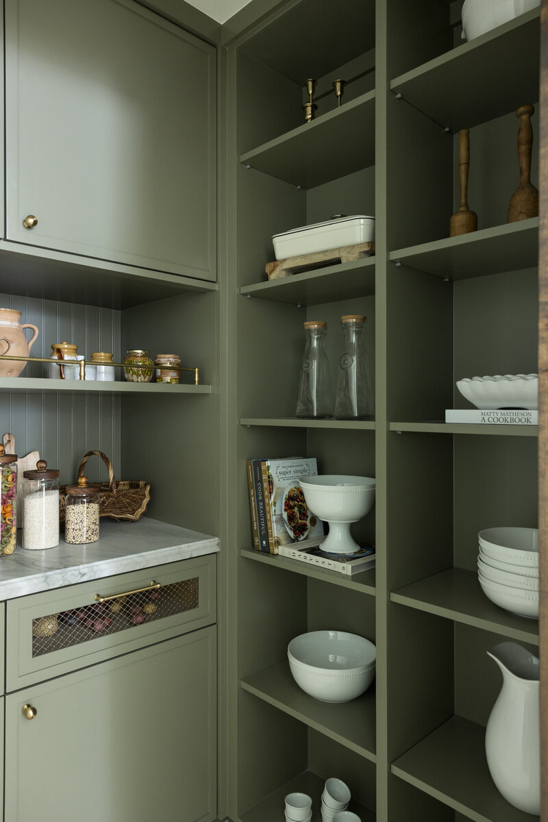 painted cabinets with quartzite countertops, ceramic tile backsplash and wall sconces with brass plumbing