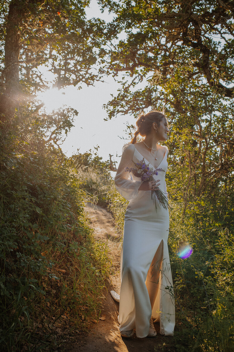 Bride holding bouquet of wildflowers in a forest