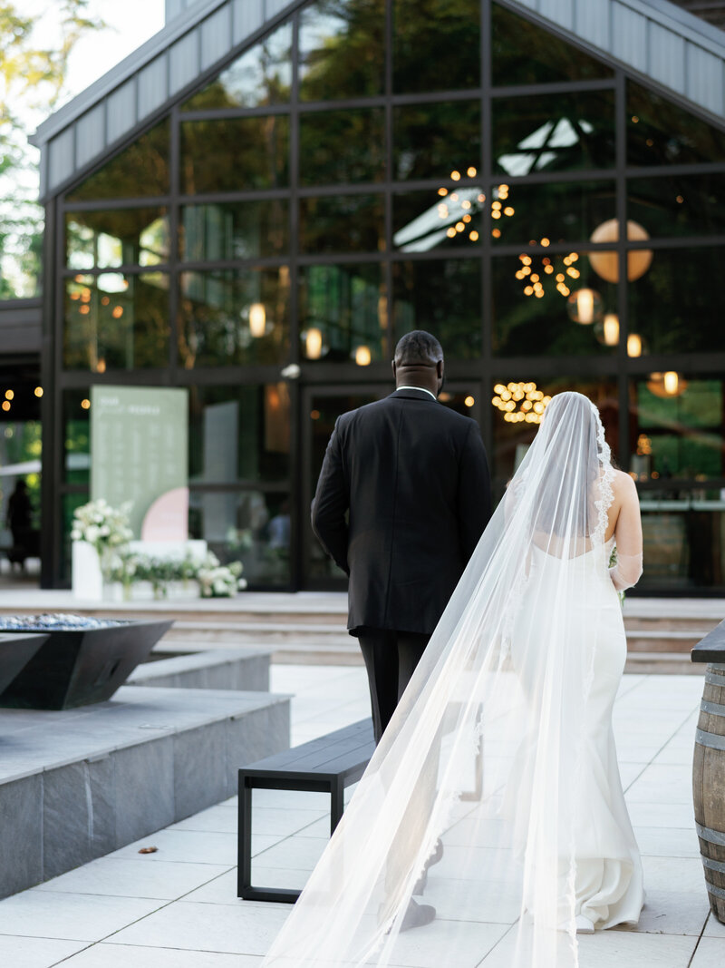 bride and groom kissing at their bridal party tosses flower pedals standing in from of a beautiful pergola decorated with flowers by wedding planners in Cleveland Ohio, Sirpilla Soirees