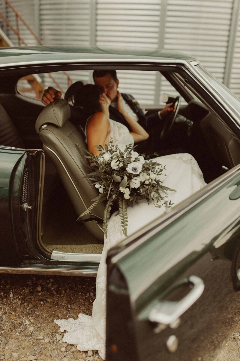 a groom and a bride kissing in the car