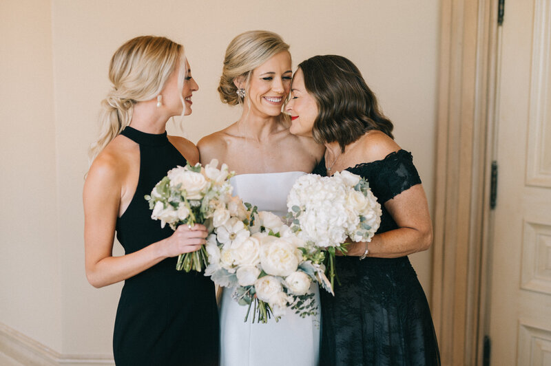bride hugs her mom and sister on her wedding day