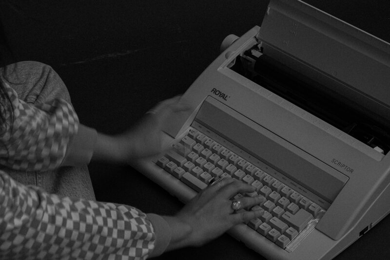 hands with rings typing on vintage royal typewriter