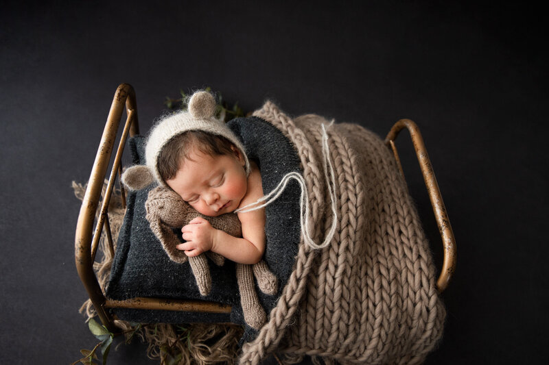 newborn sleeping on tiny bed