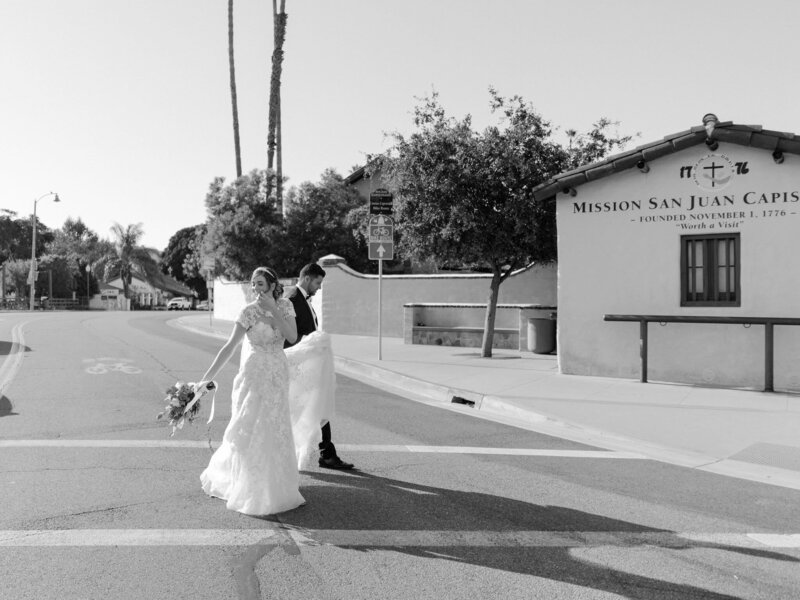 black and white image bride and groom in street