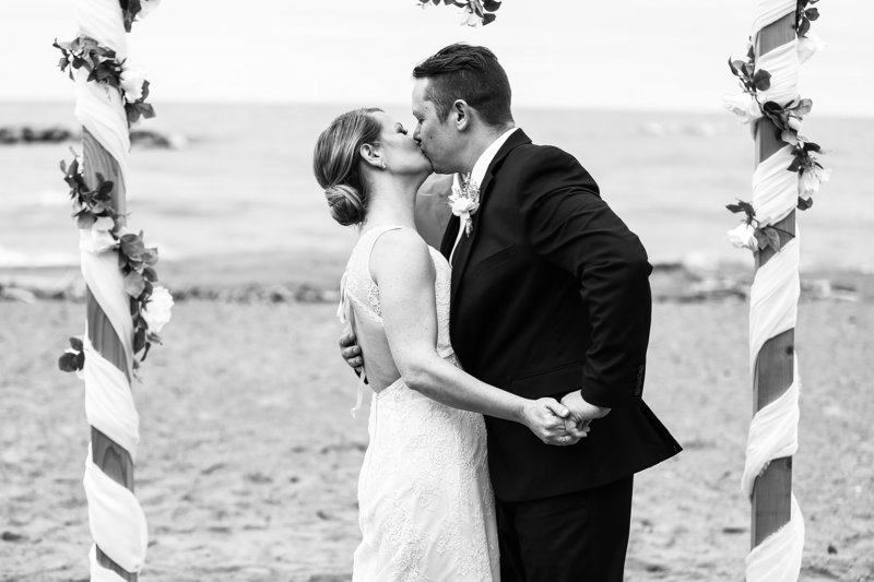 Bride and groom share first kiss at their Presque Isle beach wedding
