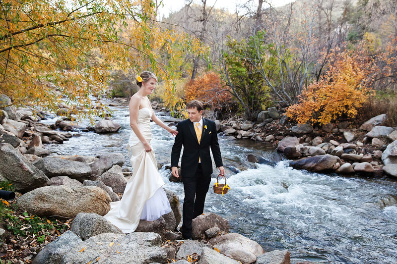 Couple walks over to Boulder Creek during wedding ceremony at Wedgewood Weddings Boulder Creek in Colorado