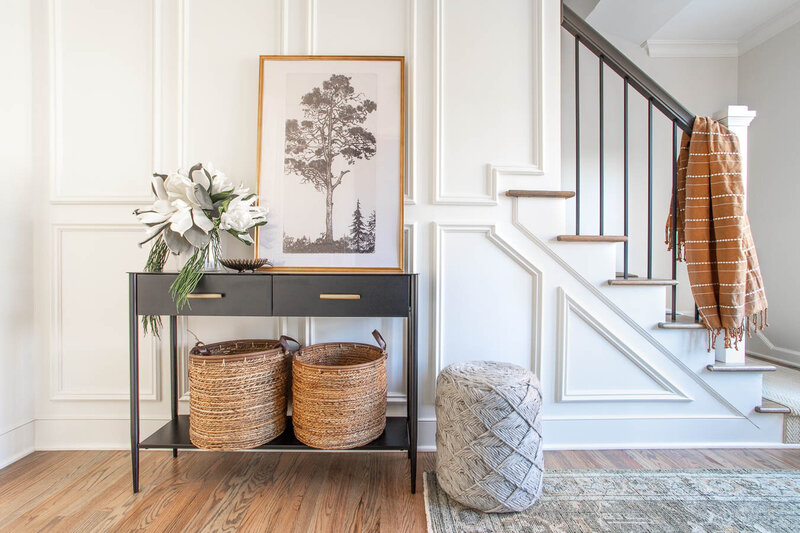 Modern entryway with hardwood floors and a black console table with baskets designed by Haven + Harbor Interiors