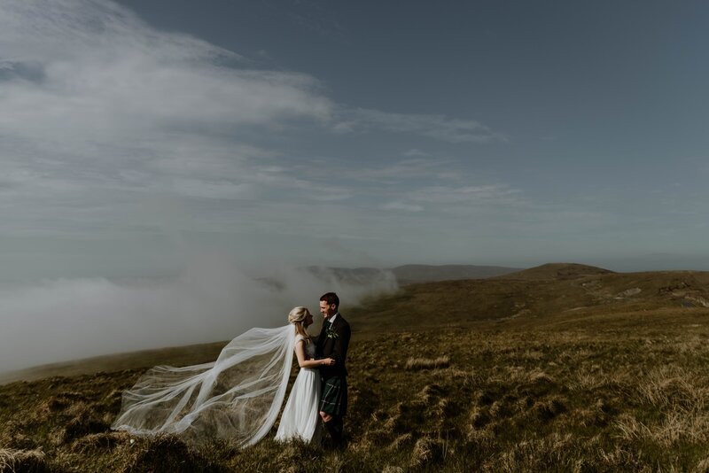 bride and groom embracing on rolling hills