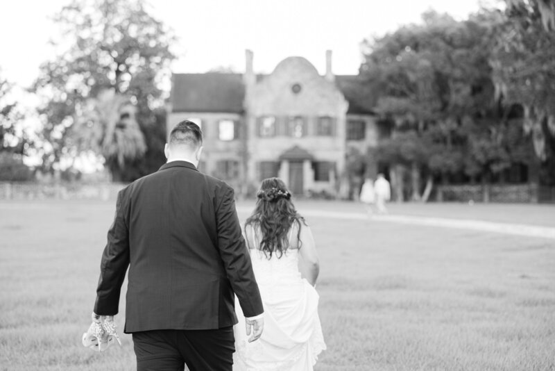 black and white image of bride and groom walking away