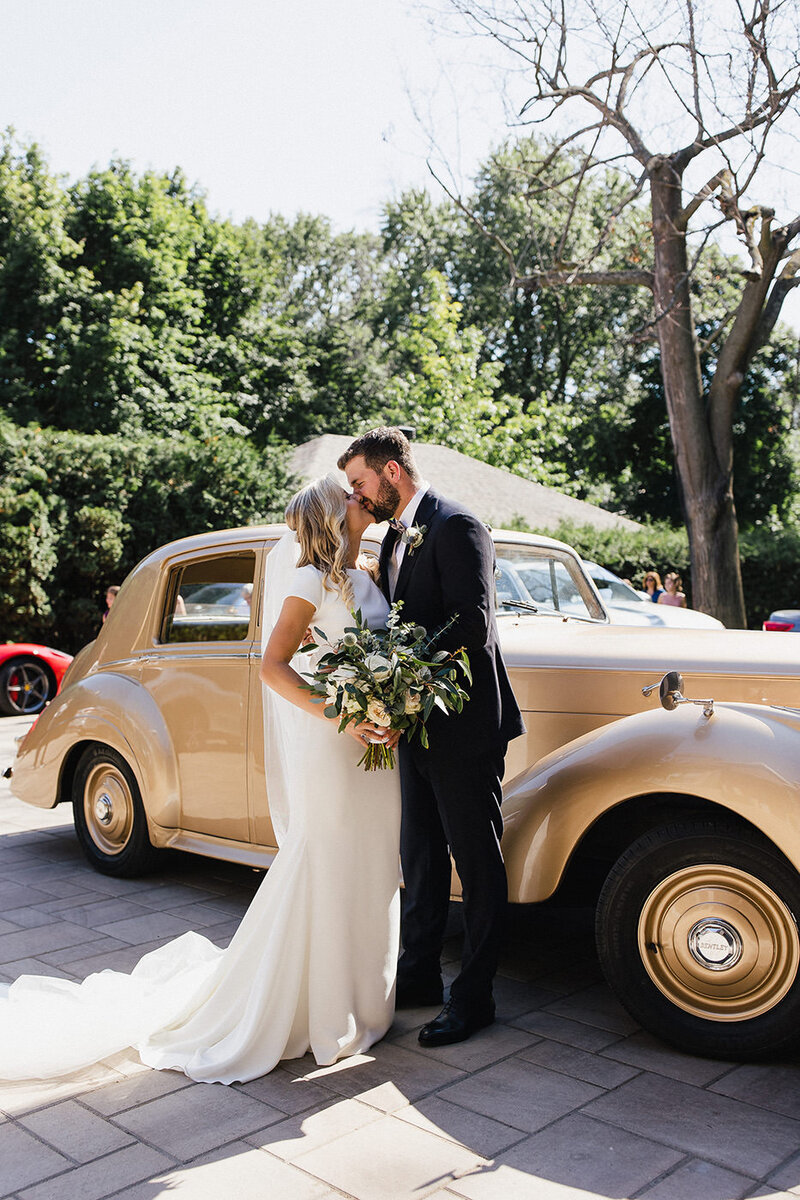 couple in front of a retro car t their wedding