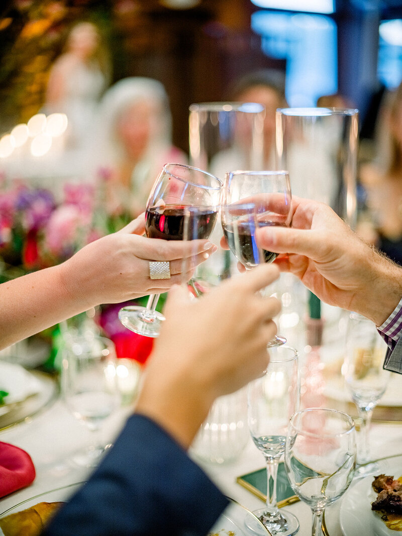 Guests toast with wine and champagne at an elegantly set table with bright florals, captured in documentary wedding photography at a Tiburon celebration.